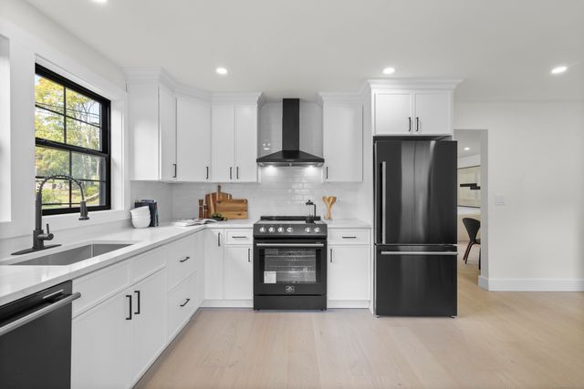 a kitchen with refrigerator a sink and a window