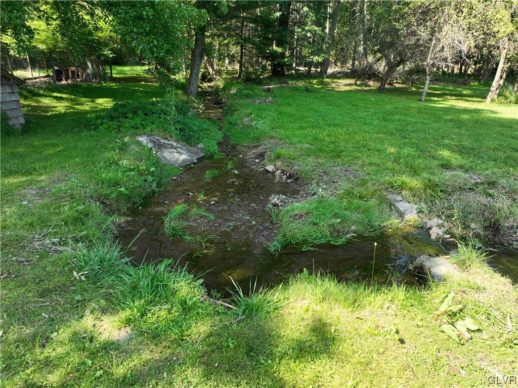 234 Rinker Road Stroudsburg, PA 18360 - Photo 42 of 49 a backyard of a house with lots of green space and lake view