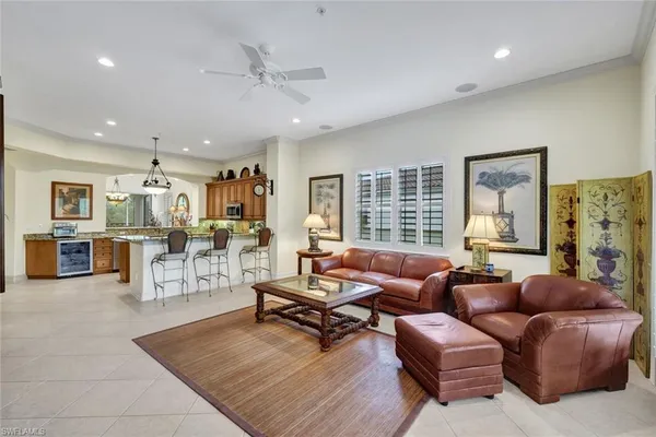 a living room with furniture kitchen view and a large window