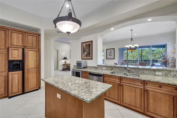 a kitchen with kitchen island granite countertop a counter space cabinets and stainless steel appliances