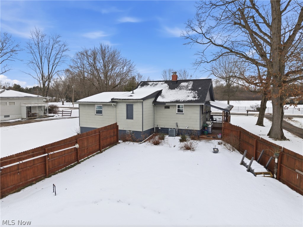 6291 Downs Road Northwest Warren, OH 44481 - Photo 34 of 44 Snow covered house featuring a fenced backyard, a chimney, and a deck