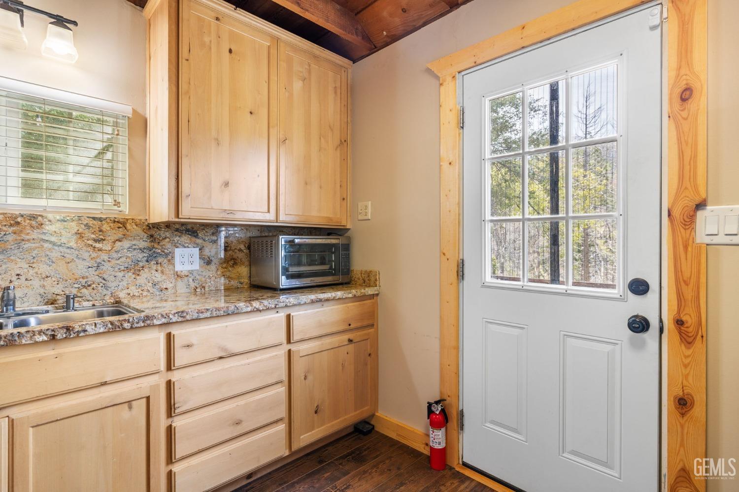 Undisclosed Address Posey, CA 93260 - Photo 28 of 53 a kitchen with granite countertop white cabinets and window