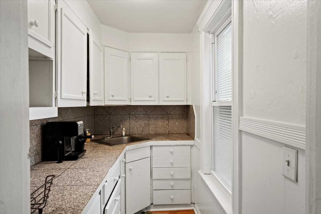 3 Wallace Street Worcester, MA 01605 - Photo 13 of 29 a kitchen with white cabinets and black appliances