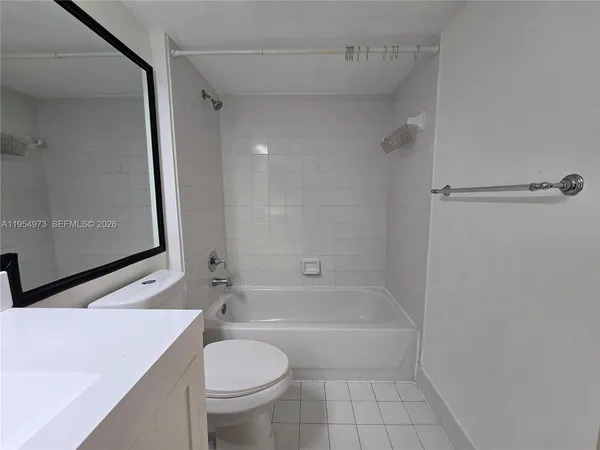 a bathroom with a granite countertop sink toilet a mirror and bathtub