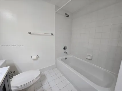 a white toilet and tub sitting next to a bathroom sink