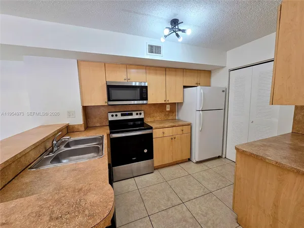 a kitchen with a refrigerator a stove top oven a sink and dishwasher