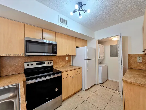 a kitchen with stainless steel appliances a stove microwave and a refrigerator