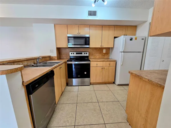 a kitchen with a stove a microwave and a refrigerator