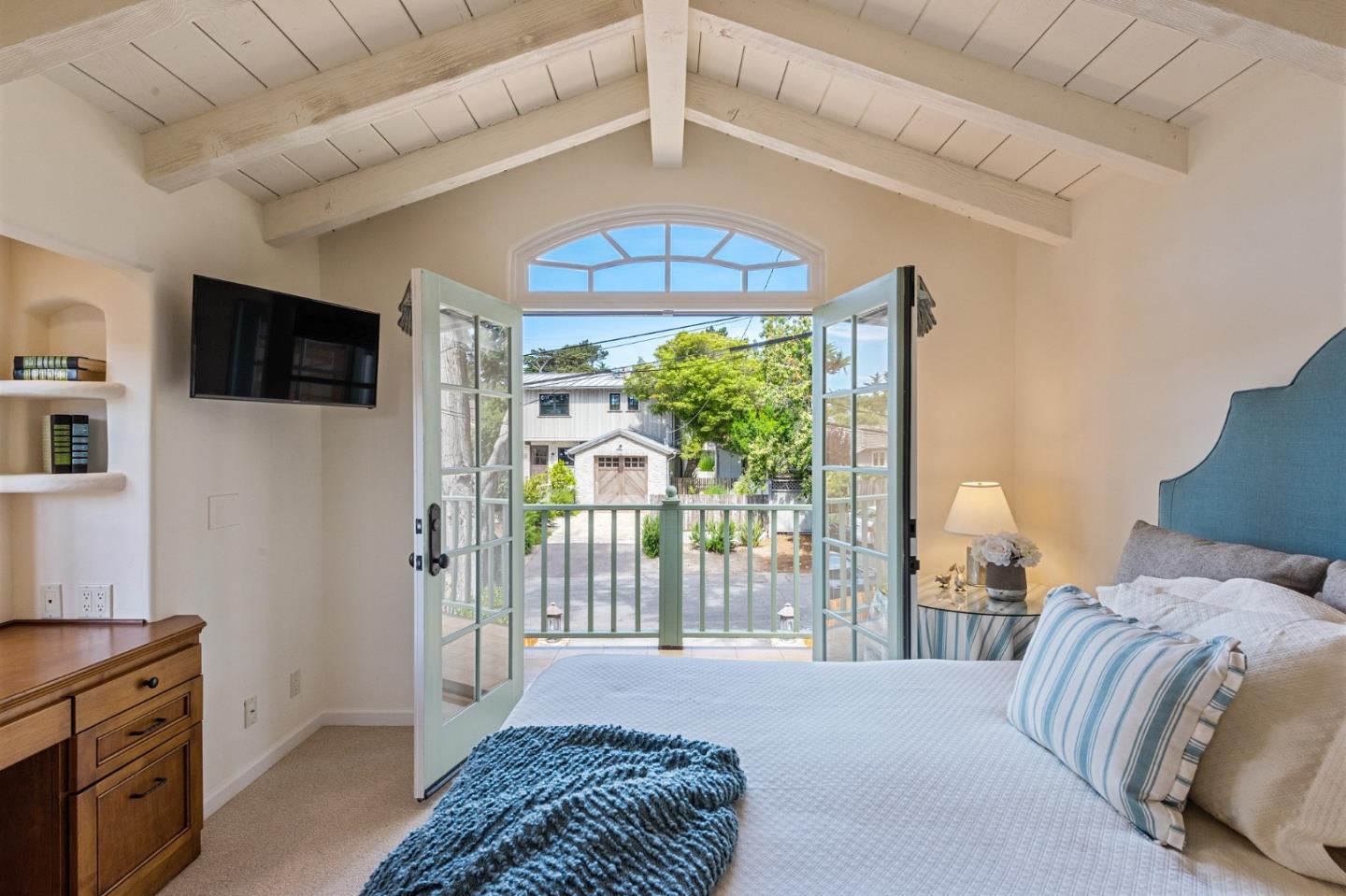 26335 Rio Avenue Carmel, CA 93923 - Photo 38 of 56 a bedroom with a balcony a bed and a television