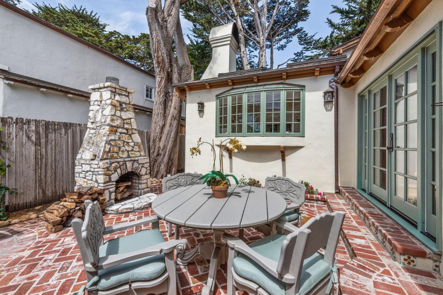 26335 Rio Avenue Carmel, CA 93923 - Photo 48 of 56 a view of a patio with table and chairs with wooden floor and fence