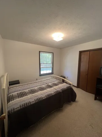 a bed sitting in a bedroom next to a window
