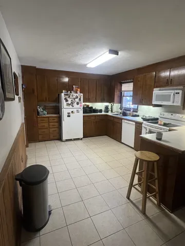 a kitchen with stainless steel appliances kitchen island granite countertop a sink and white cabinets