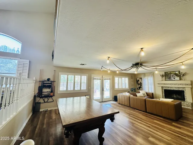 a living room with furniture dining table wooden floor and a fireplace