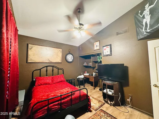 a bedroom with a bed window and a flat screen tv
