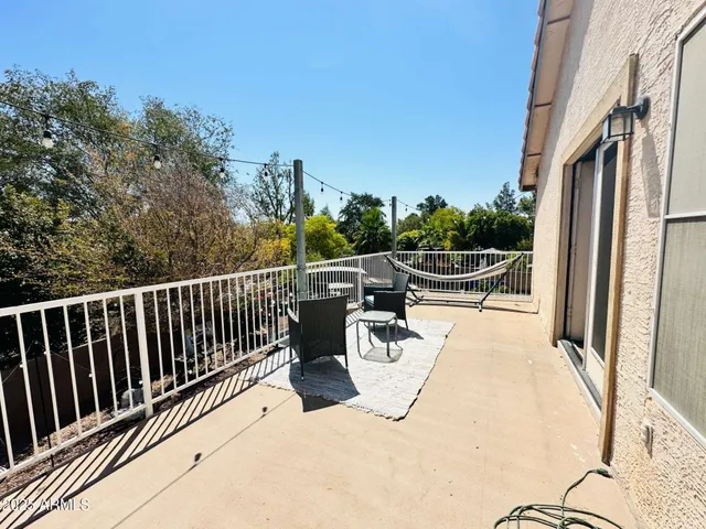 a view of roof deck with wooden fence and trees