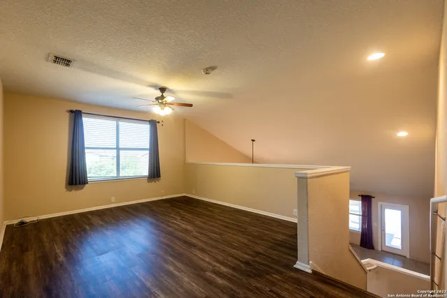 a view of an empty room with wooden floor