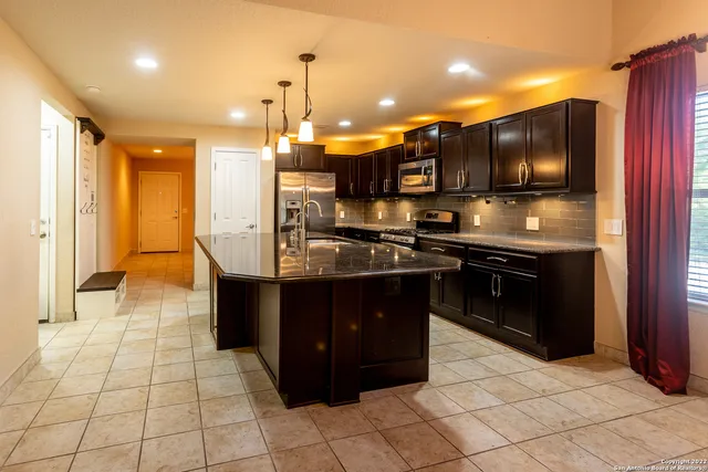 a kitchen with granite countertop stainless steel appliances and wooden cabinets