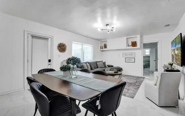 a view of a dining room with furniture and kitchen view