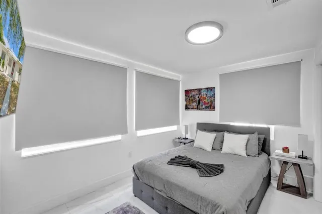 a bedroom with a bed and painting on the wall