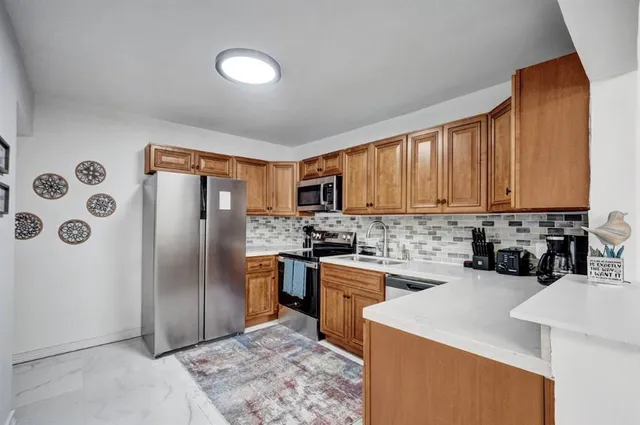 a kitchen with stainless steel appliances granite countertop a stove a sink dishwasher and a microwave oven with cabinets