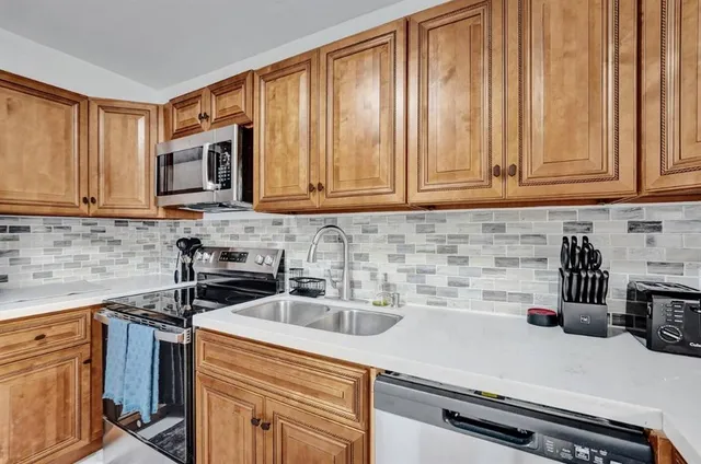a kitchen with white cabinets and sink