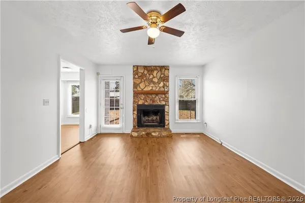 a view of an empty room with a fireplace and a window