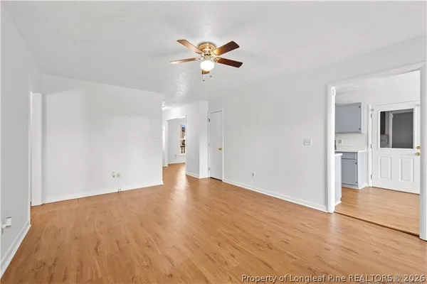 a view of a livingroom with wooden floor and a ceiling fan
