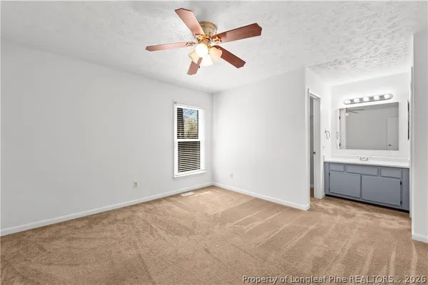 an empty room with a bathroom and a sink
