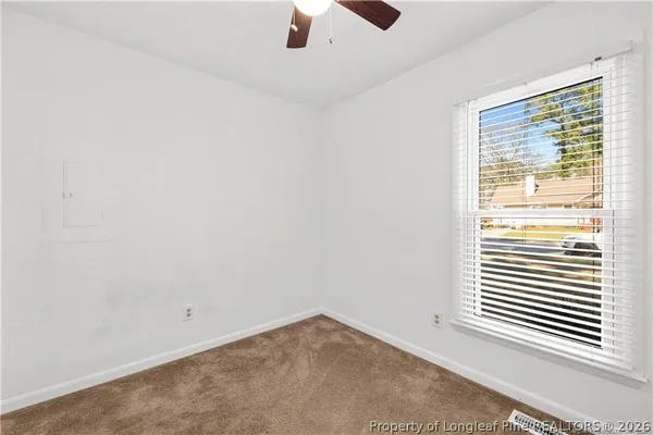 an empty room with a window and a ceiling fan