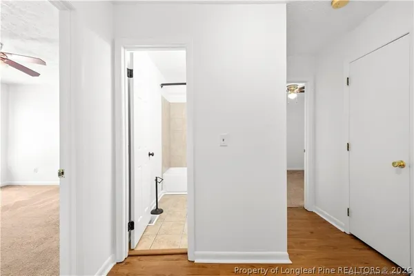 a view of a hallway with wooden floor and staircase