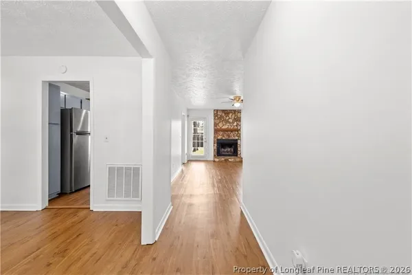 a view of a hallway with wooden floor and closet