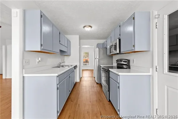 a kitchen with kitchen island granite countertop a sink a counter top space stainless steel appliances and cabinets