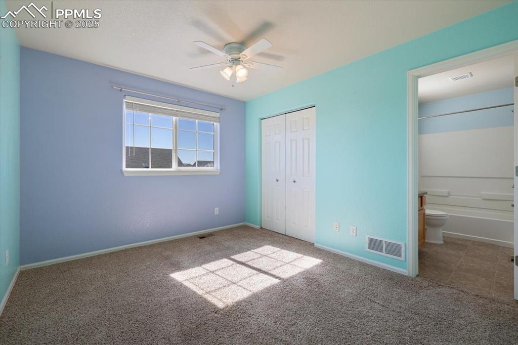 13038 Devil's Thumb Place Peyton, CO 80831 - Photo 22 of 44 Upper Level Bedroom #2 with neutral carpet, lighted ceiling fan, and adjoining bathroom.