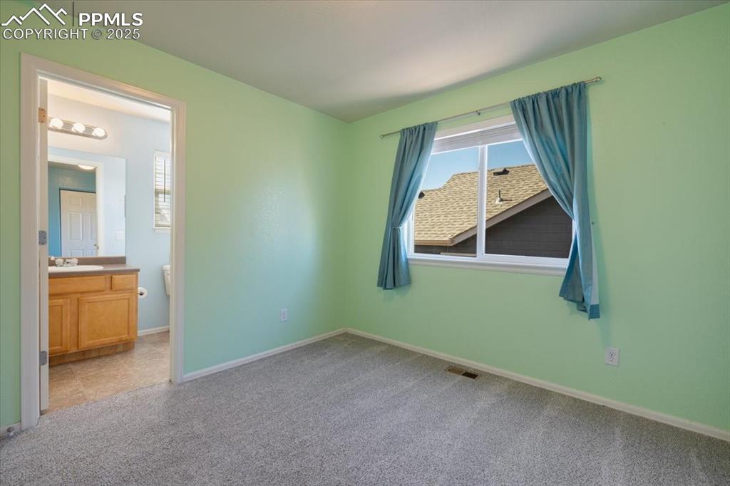 13038 Devil's Thumb Place Peyton, CO 80831 - Photo 24 of 44 Upper Level Bedroom #3 with neutral carpet and adjoining Bathroom