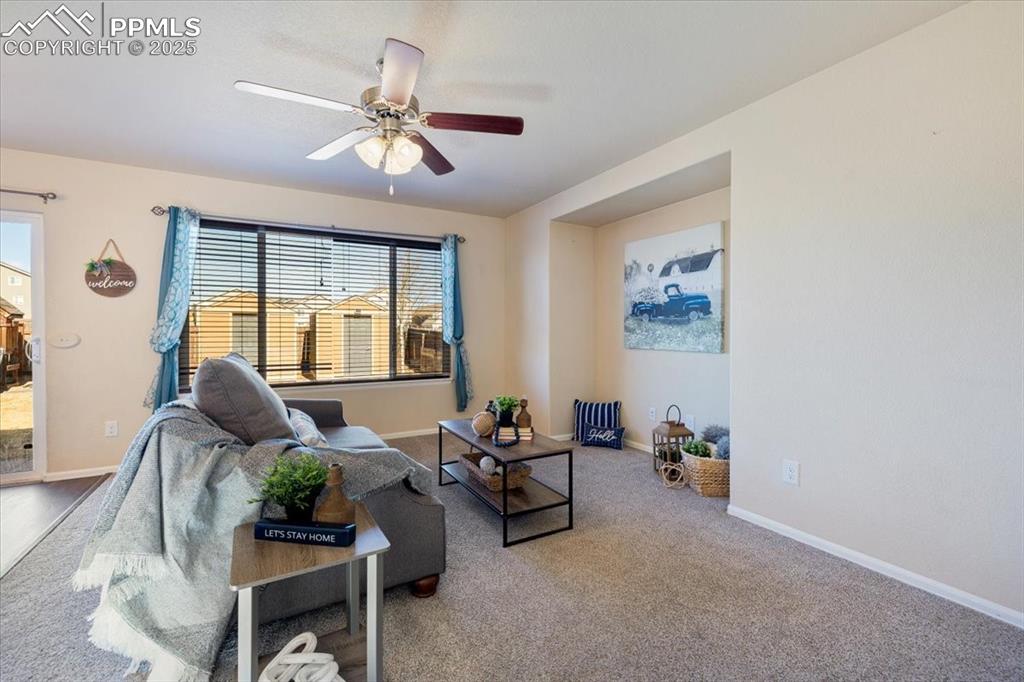 13038 Devil's Thumb Place Peyton, CO 80831 - Photo 3 of 44 The inviting living room boasts neutral carpet, a lighted ceiling fan, an entertainment recess, and a large window overlooking the fenced backyard.