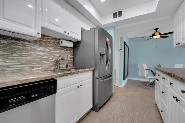 a kitchen with stainless steel appliances a stove refrigerator and cabinets