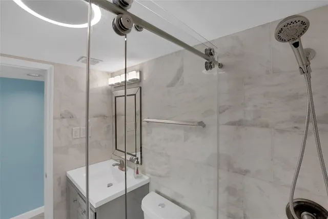 a bathroom with a sink a toilet and shower