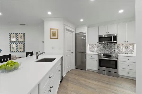 a kitchen with stainless steel appliances a stove a sink and a refrigerator