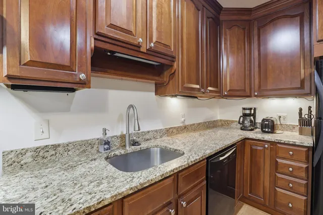 a kitchen with granite countertop a sink and cabinets