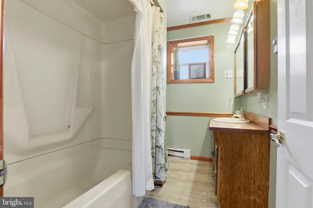 a bathroom with a tub sink and mirror