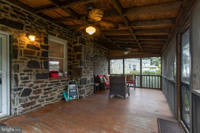 a view of a porch with furniture and wooden floor