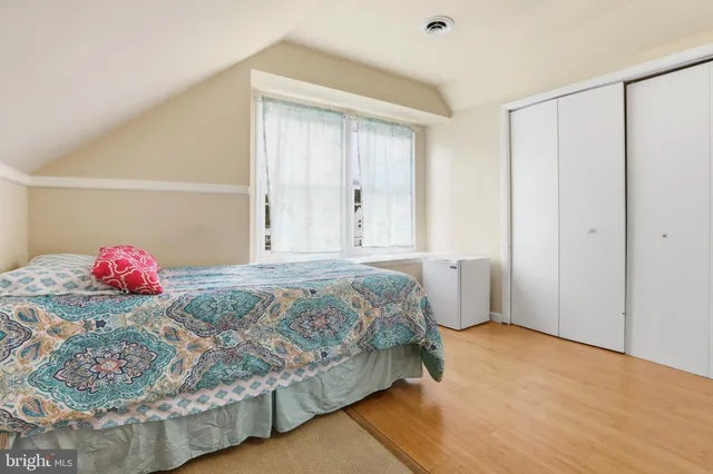 a bedroom with a bed flat screen tv and windows