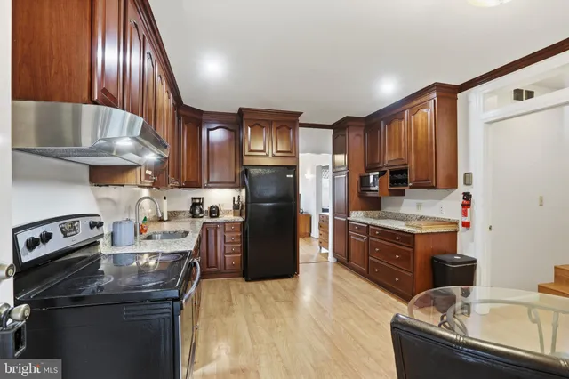 a kitchen with kitchen island granite countertop a sink stainless steel appliances and cabinets