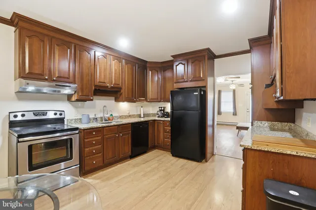 a kitchen with stainless steel appliances granite countertop a refrigerator stove and sink