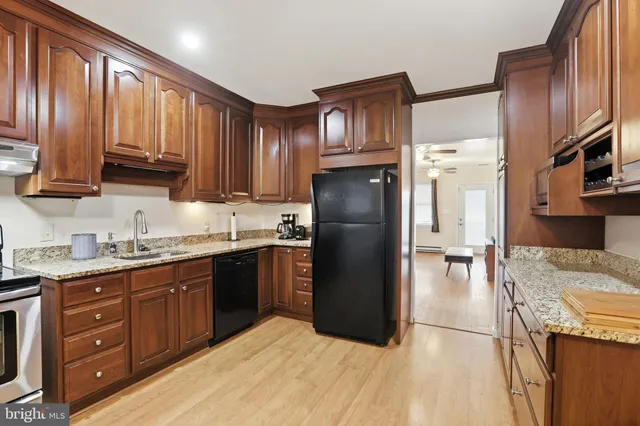 a kitchen with stainless steel appliances granite countertop a refrigerator a stove a sink and a microwave