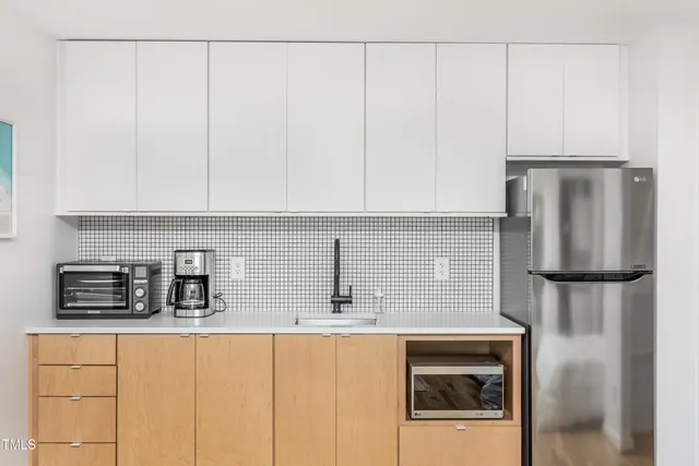 a kitchen with stainless steel appliances a refrigerator and cabinets