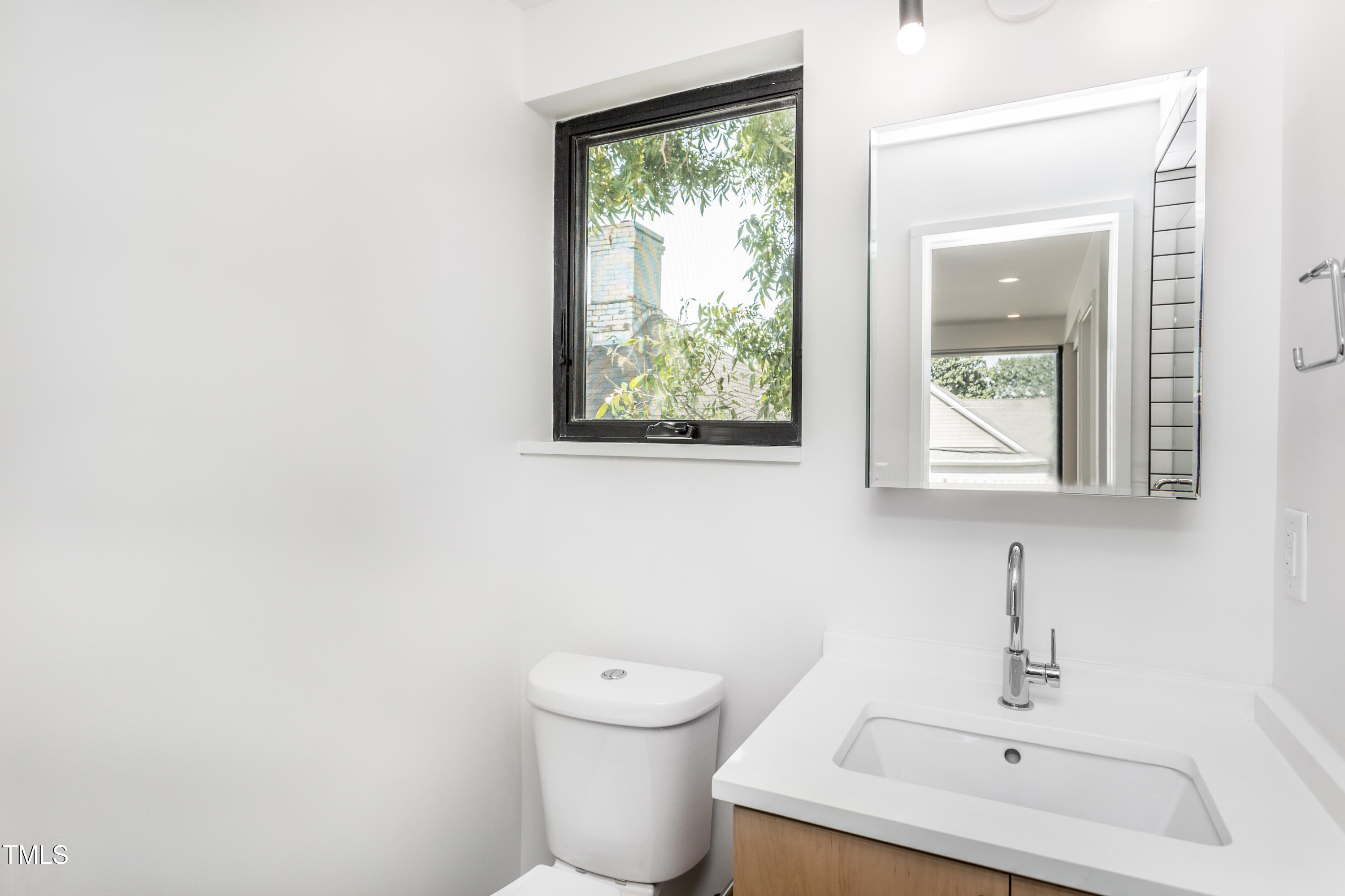 123 Idlewild Avenue, Unit 202 Raleigh, NC 27601 - Photo 17 of 20 a bathroom with a toilet a sink and mirror