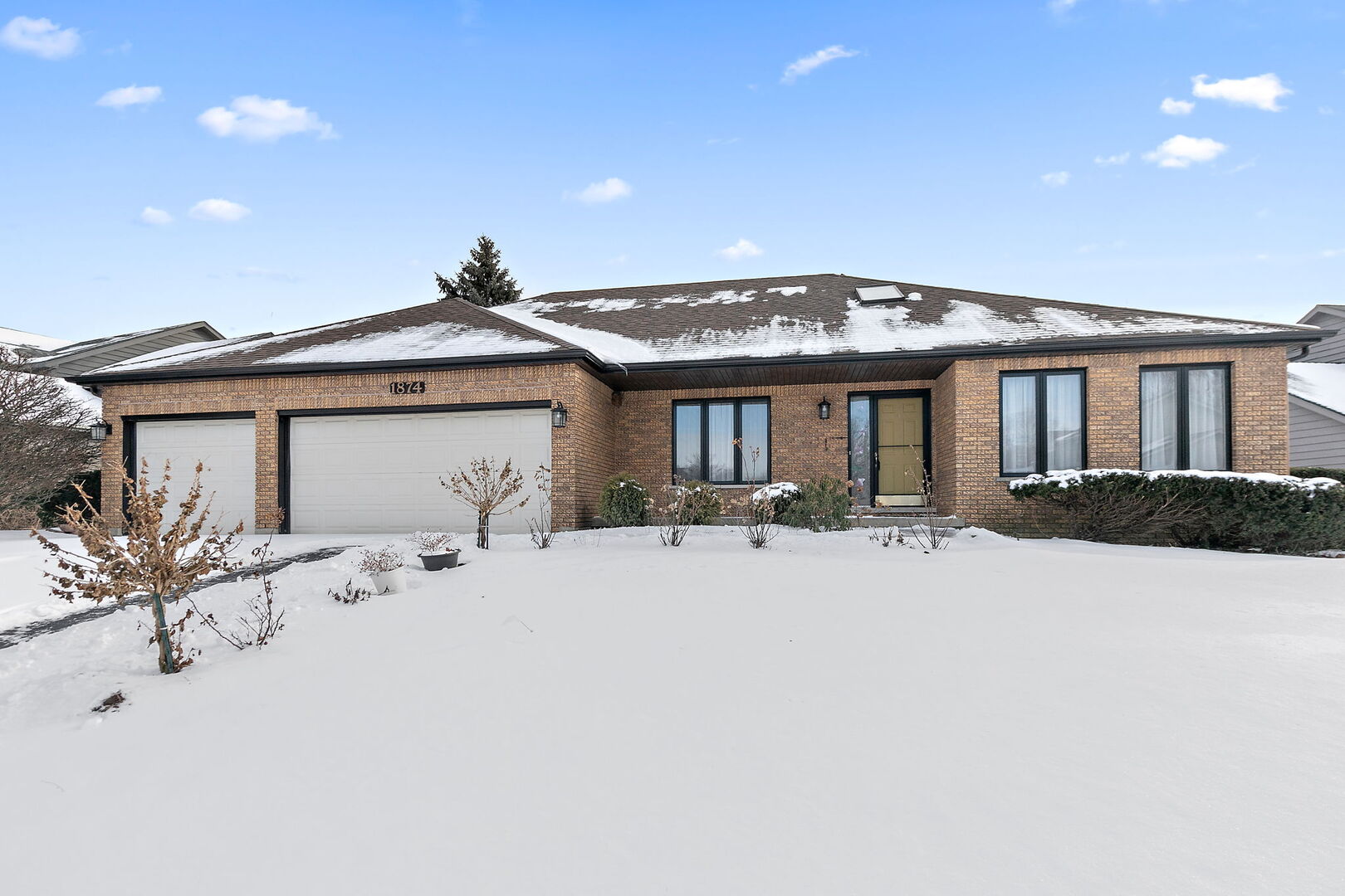 a view of a house with wooden roof and a table and chairs under an umbrellas