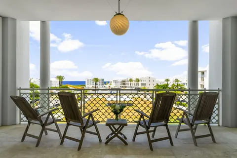 a view of a terrace with furniture and floor to ceiling window