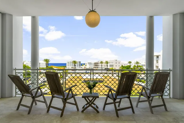 a view of a terrace with furniture and floor to ceiling window